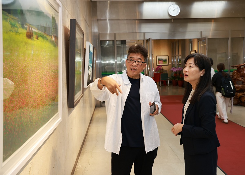 本行舉辦「2026林榮．臺灣的故事油畫創作展」，由知名油畫家林榮（左）為本行副總經理蔡慈瑛（右）導覽畫作。