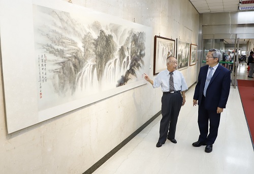 本行邱副總經理（右）聆聽藝術家吳瑞昌（左）導覽其作品。