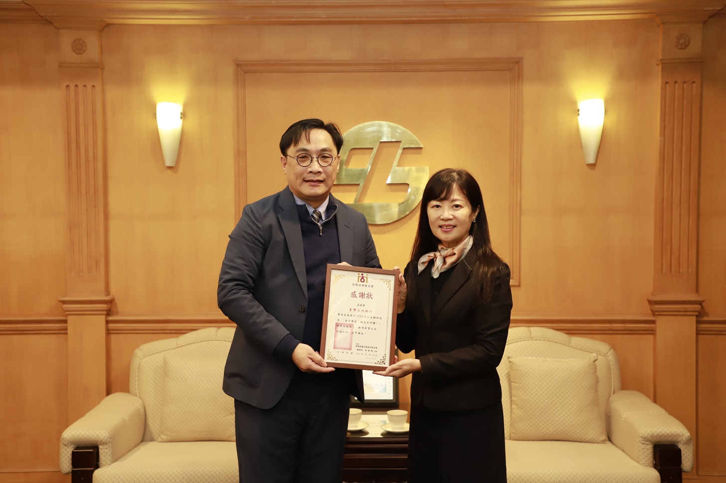 脊髓損傷基金會執行長蕭英成（左）頒贈感謝狀予本行副總經理蔡慈瑛（右）。
