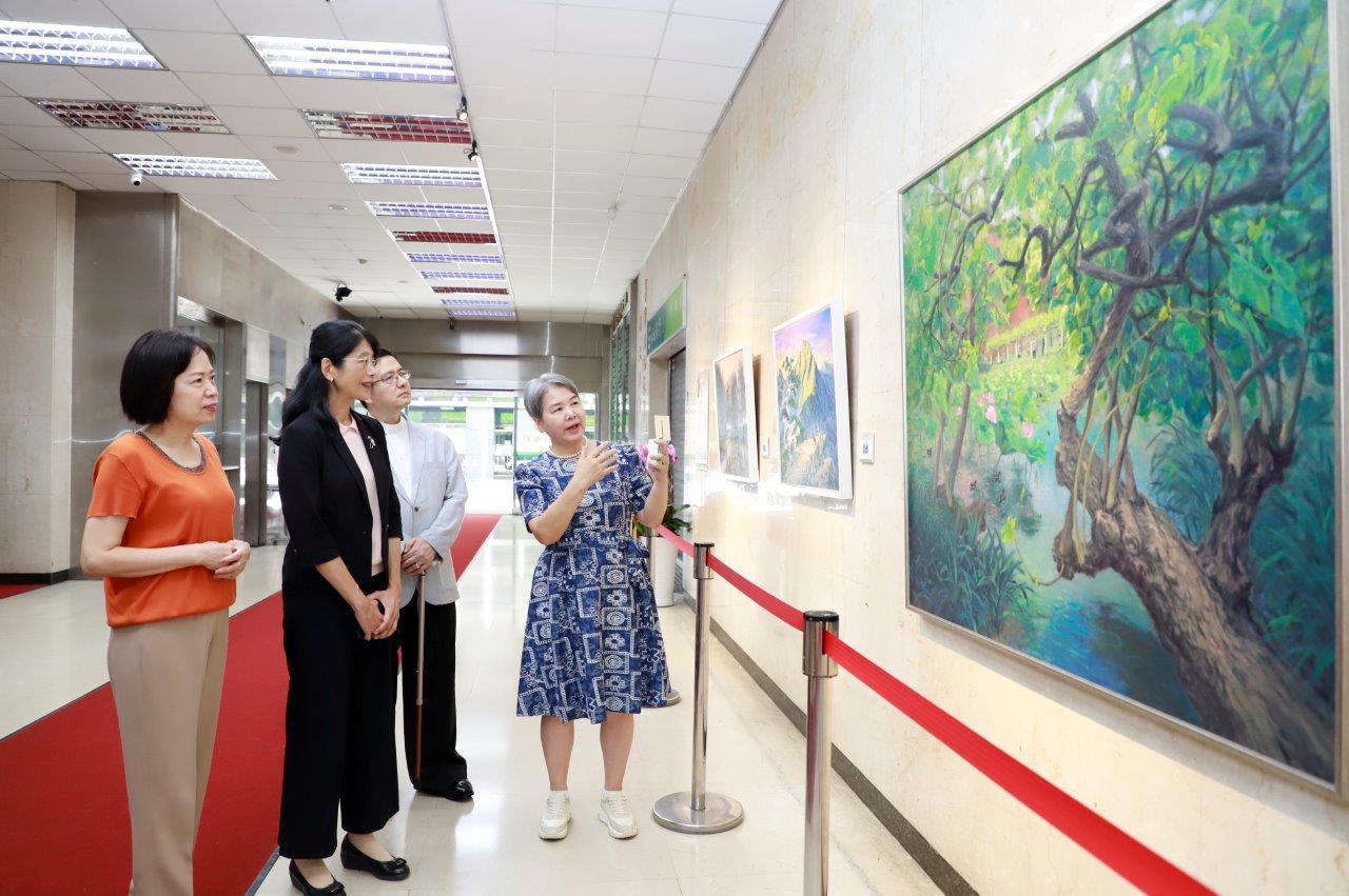 藝術家邱凡庭（右一）為本行副總經理程佩瑜（左二）、董事會主任秘書鄭瑟琴（左一）及博士吳世全（右二）導覽畫作。