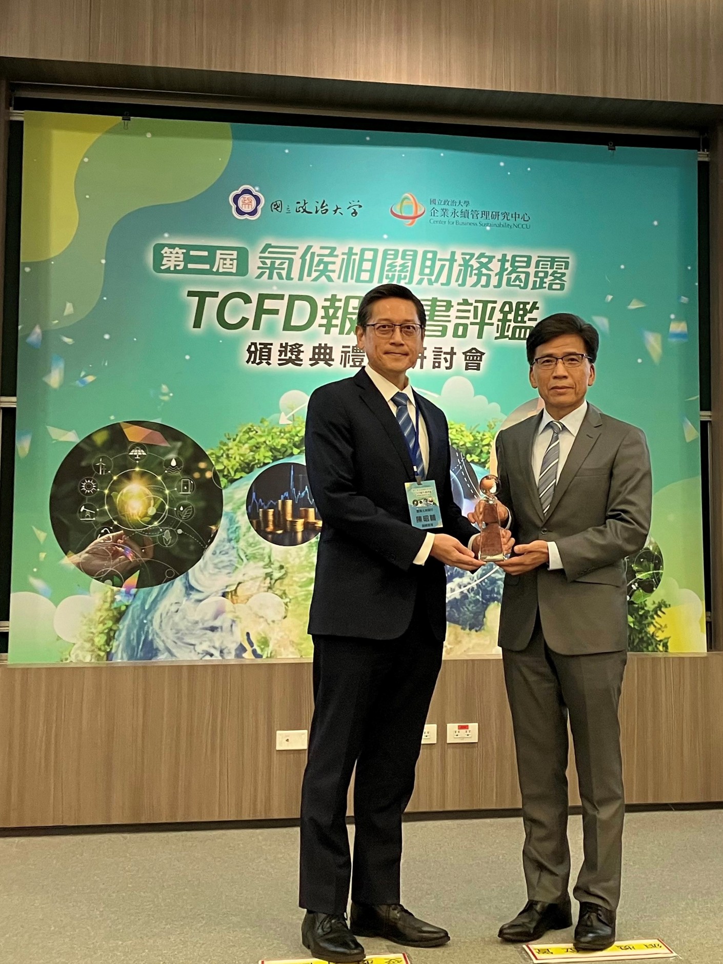本行榮獲國立政治大學第二屆氣候相關財務揭露（TCFD）報告書評鑑銀行類「進步績優單位」，由金融監督管理委員會主委彭金隆(右)頒獎予本行副總經理陳昭輔(左)。