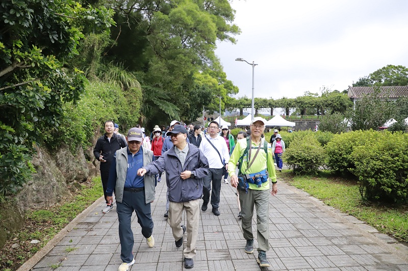 本行董事長何英明、總經理張志堅及活動領隊漫步於健行步道。