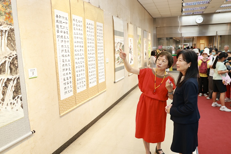 本行舉辦「墨筆昇驊－蕭佳驊書畫藝術展」，由書畫藝術家蕭佳驊（左）為本行副總經理蔡慈瑛（右）導覽畫作。