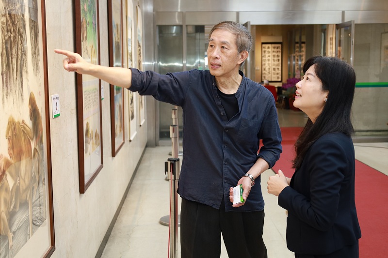 書畫藝術家郭天中（左）為本行副總經理蔡慈瑛（右）導覽其畫作。
