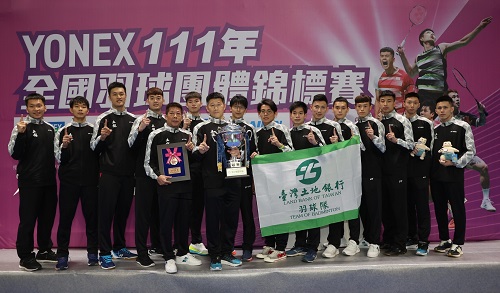 本行羽球隊管理葛新銘(前排左、持獎牌)、總教練李松遠(前排右、持獎盃)與教練團及全體球員於獲勝後合影。