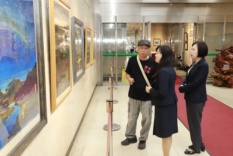 藝術家黃運祥（左）為本行副總經理蔡慈瑛（中）、本行董事會主任秘書鄭瑟琴（右）導覽畫作。