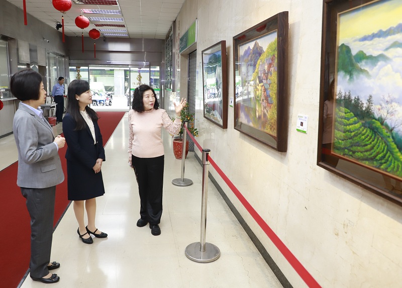 臺北藝術家蕭妙修（右）為本行副總經理蔡慈瑛（中）、本行董事會主任秘書鄭瑟琴（左）導覽其畫作。