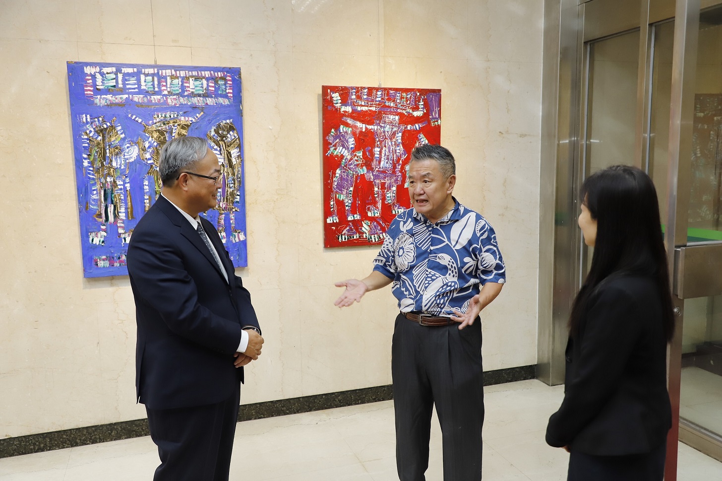 臺灣多媒材創作家曾郁文（中）為本行總經理張志堅（左）及本行副總經理蔡慈瑛（右）導覽畫作