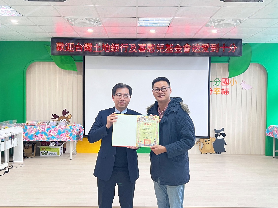 新北市十分國小學輔主任蕭仕賢(右)頒贈感謝狀予本行企劃部副理蘇晏逸（左）。